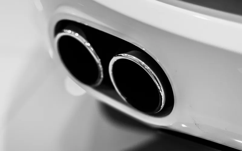 Close-up of polished chrome exhaust tips on the rear bumper of a sports car