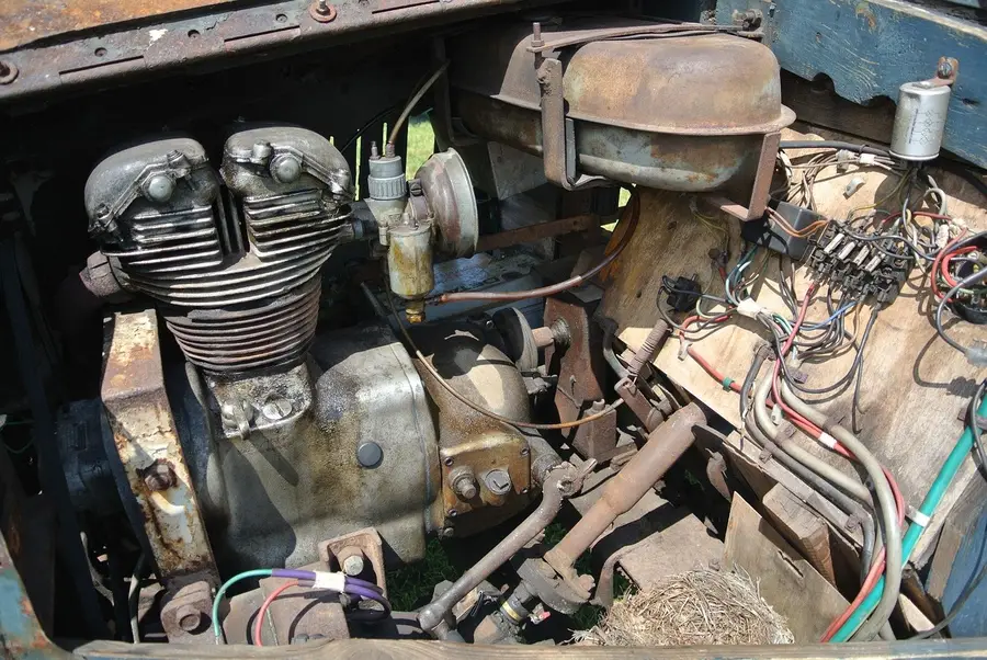 Aged engine bay with mixed color wiring and tape marks