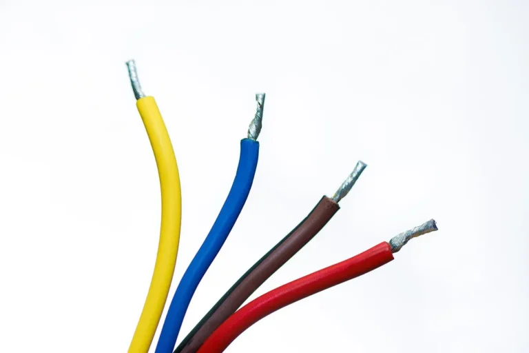 Four insulated wires in yellow, blue, brown and red with stripped copper ends