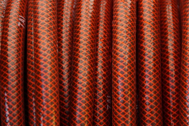 Braided reinforced hoses lying side by side