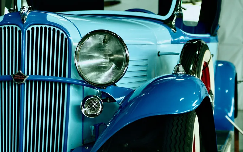 A row of parked 1920s-era classic automobiles similar to those featured in Downton Abbey