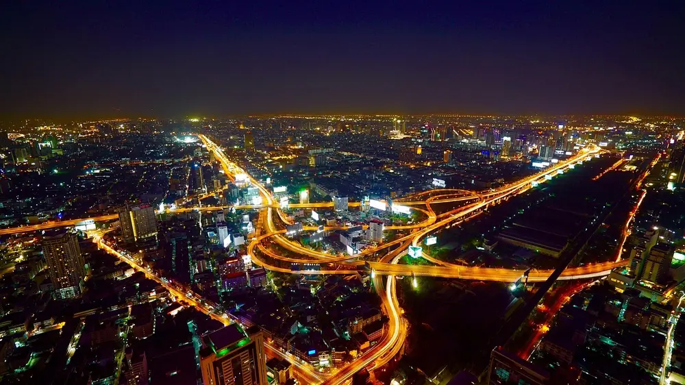 Elevated expressway interchange with light trails in a large city at night