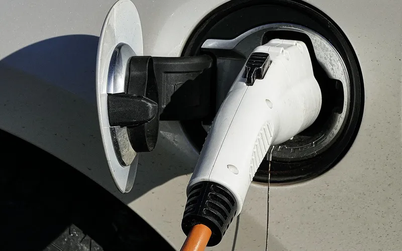 Electric car plugged into a public charging station to recharge its battery