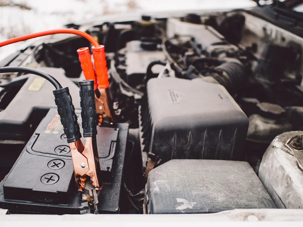 Jumper cables connected to a car battery