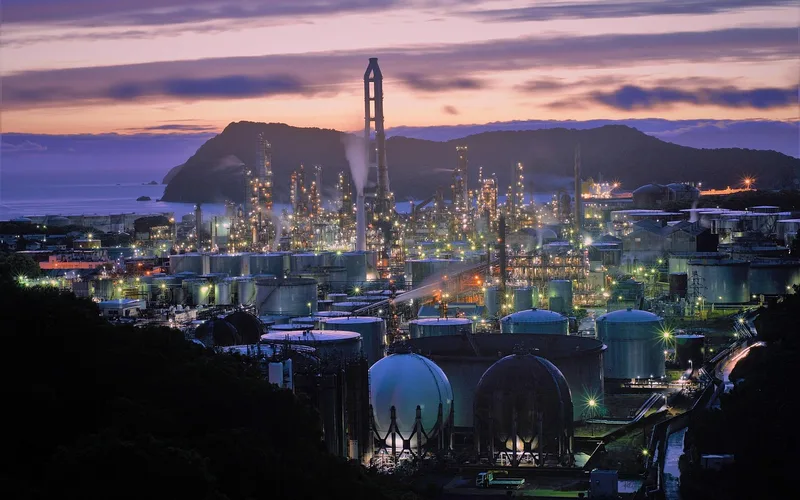 Large industrial manufacturing plant exterior at dusk, similar in scale to Tesla's Gigafactory sites