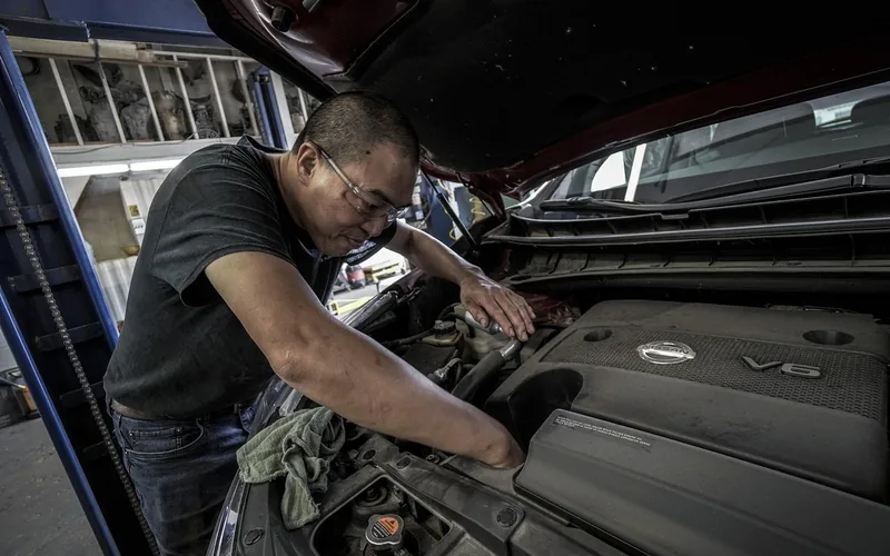 mechanic performing an oil change on a car in a repair shop