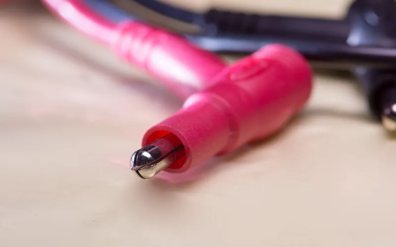 Multimeter test lead tip resting on a work surface