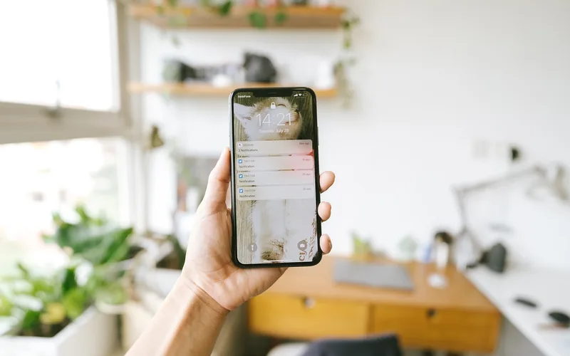 Text message notifications need to reach the phone before they can mirror to the watch Hand holding a smartphone showing incoming text message notifications