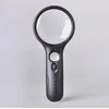 Handheld lighted magnifying glass with a black handle