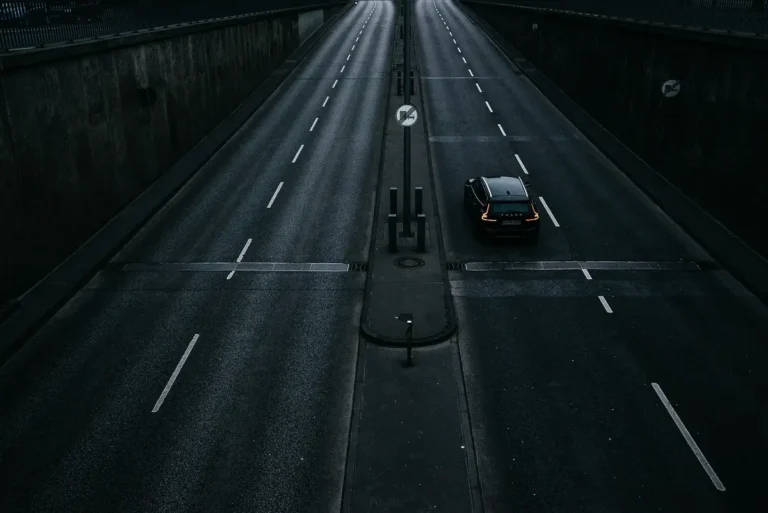 A single car driving on an empty multi-lane road