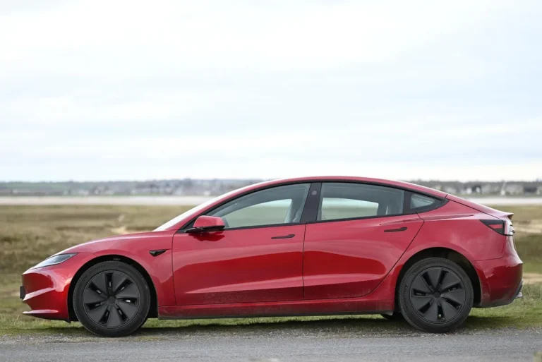 Red Tesla Model 3 parked, side view