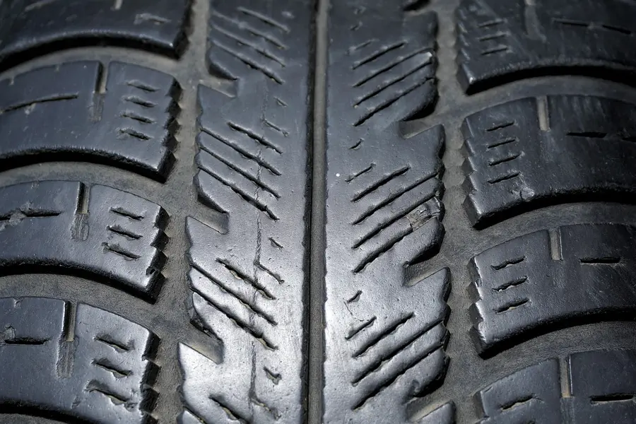 Close-up of a car tire tread with deep grooves and sipes