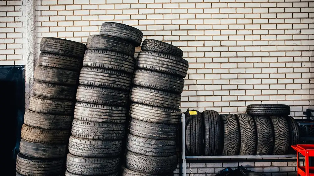 Stacks of used tires on shelves inside an auto service garage