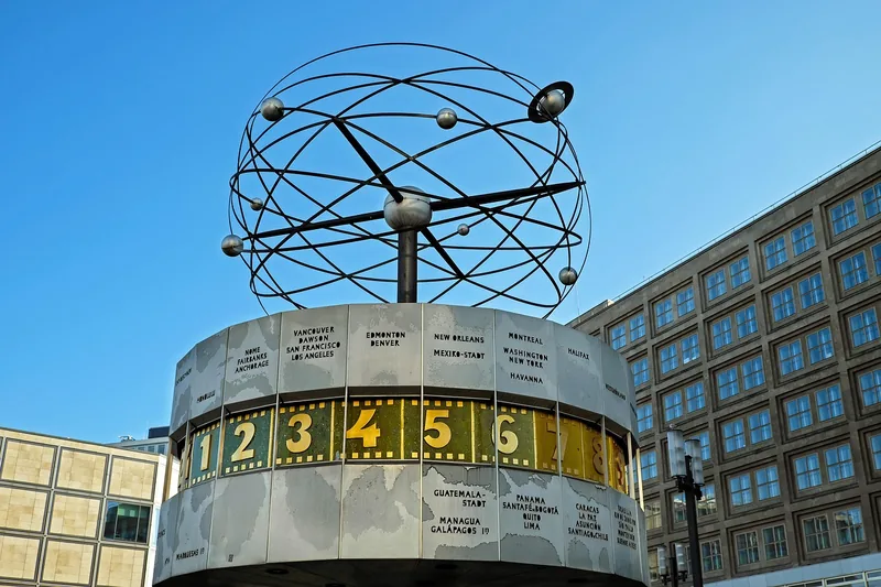 Public world time clock with city names grouped by time zone