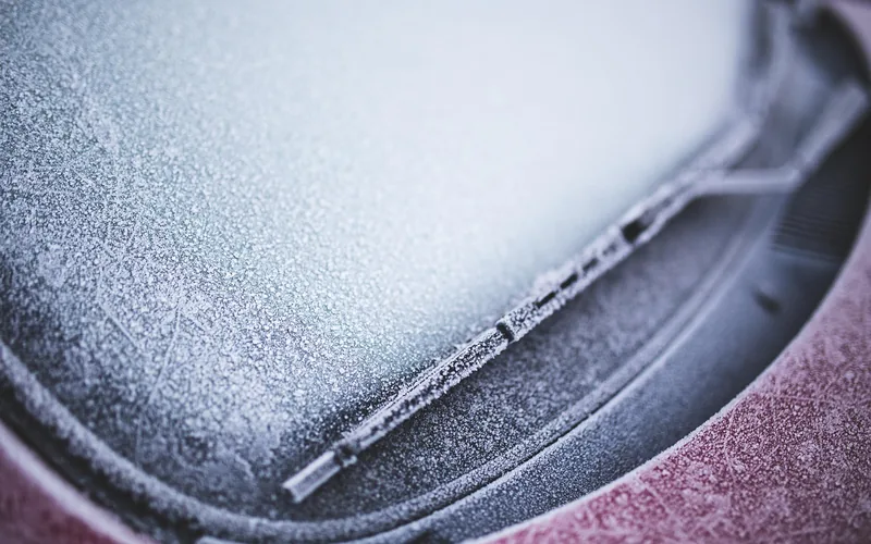 ice crystals covering a car windshield on a cold winter morning ice crystals covering a car windshield on a cold winter morning