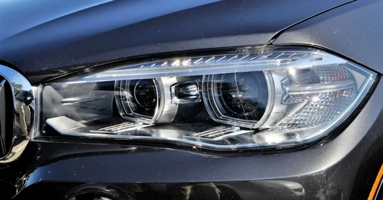 Close-up of a modern car LED headlight on a dark metallic body