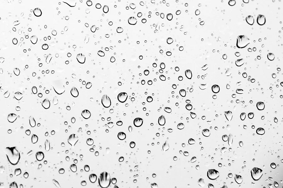 Water droplets of different sizes on a pane of glass