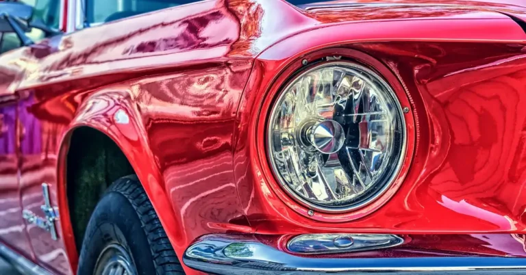 Glossy red car fender and headlight with sharp paint reflections