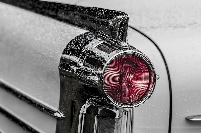 Water droplets on a car tail lamp and rear fender