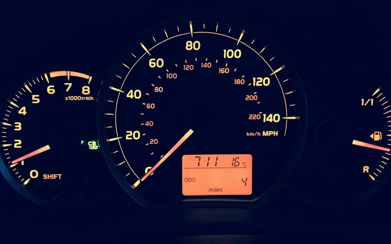 Car dashboard showing speedometer and low mileage odometer reading Car dashboard showing speedometer and low mileage odometer reading