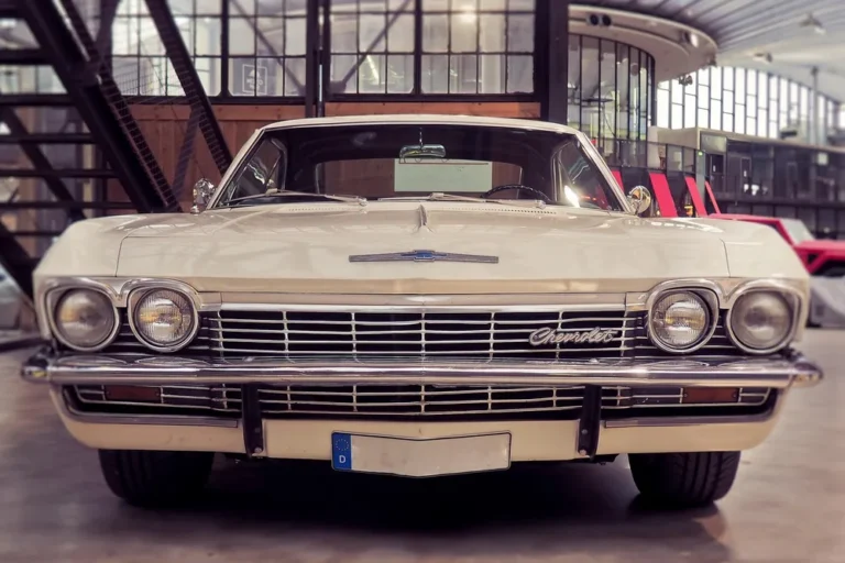 Front view of a cream-colored 1960s Chevrolet Impala in a classic car hall