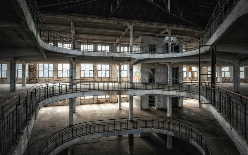 Empty multi-level commercial building interior with balconies and large windows