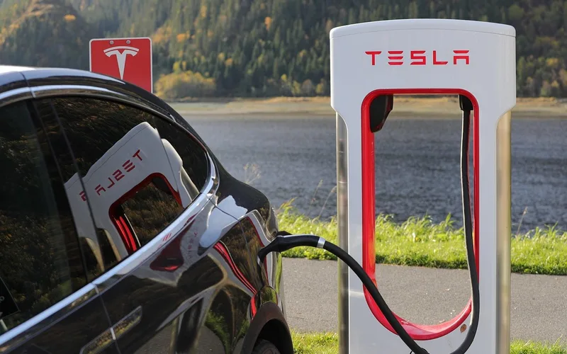 EV charging station Electric vehicle plugged into a public fast-charging station