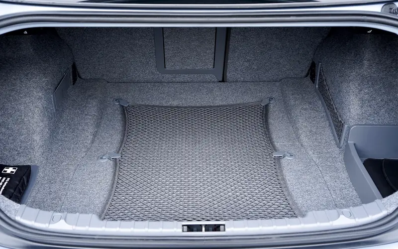 Open sedan trunk showing empty cargo space with a cargo net