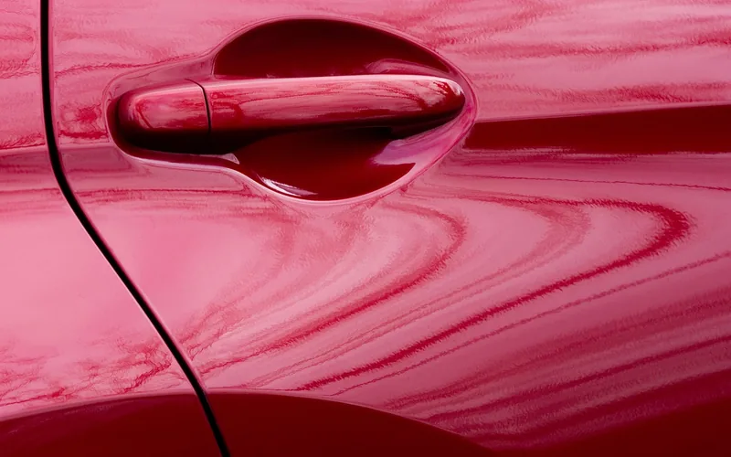 Glossy red car door panel with smooth reflections