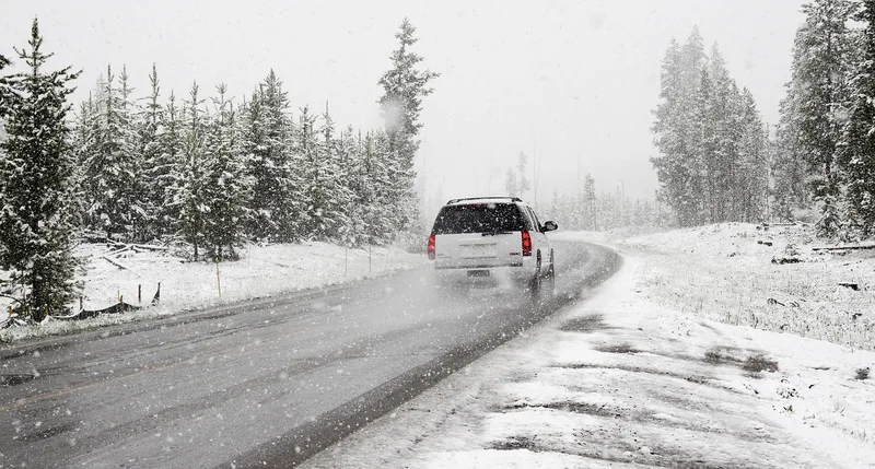 white SUV driving on a snowy road