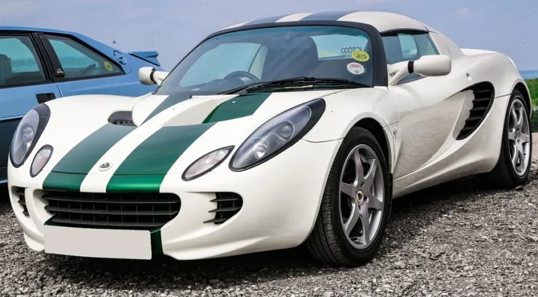 White Lotus Elise sports car with green racing stripes parked on gravel