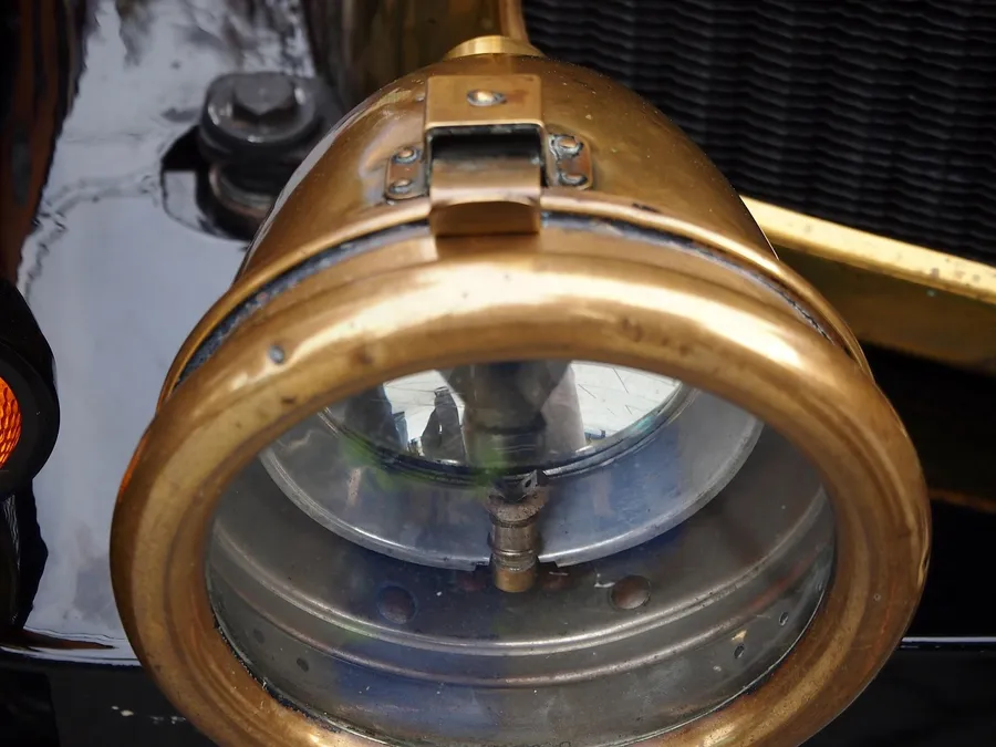 Close view of a brass headlamp on an antique automobile