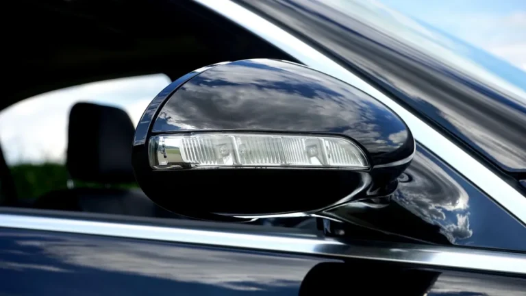 Turn signal indicator built into the side mirror of a black car