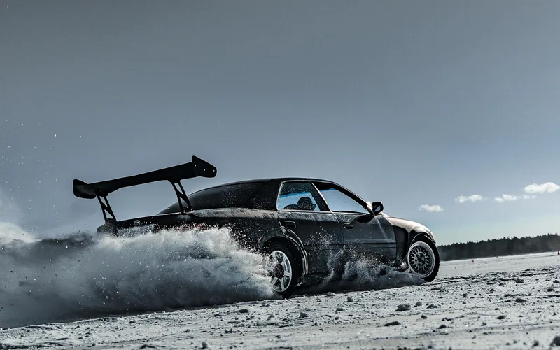Car with a large rear wing sliding through snow