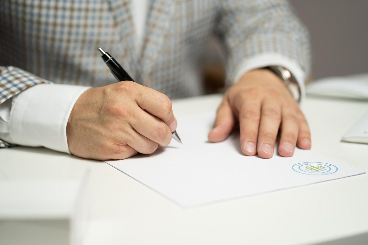 A buyer signing a car loan agreement at a dealership
