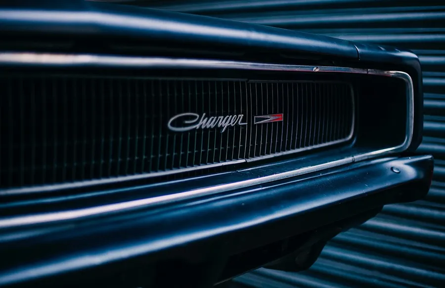 Close-up of the chrome Charger script badge on a classic Dodge Charger grille