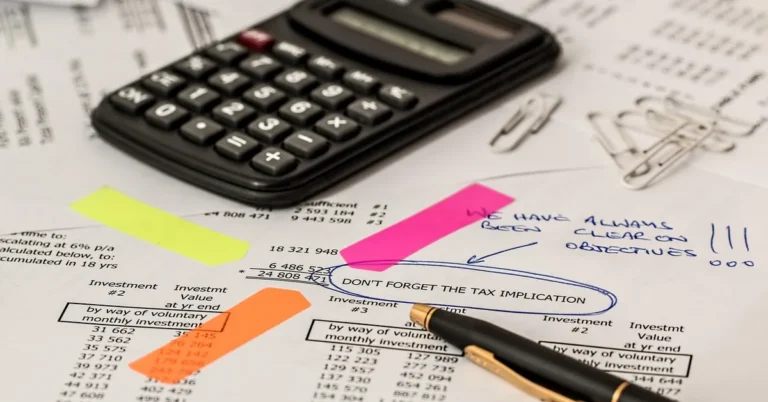 Calculator and financial paperwork representing how a credit score factors into car insurance rates