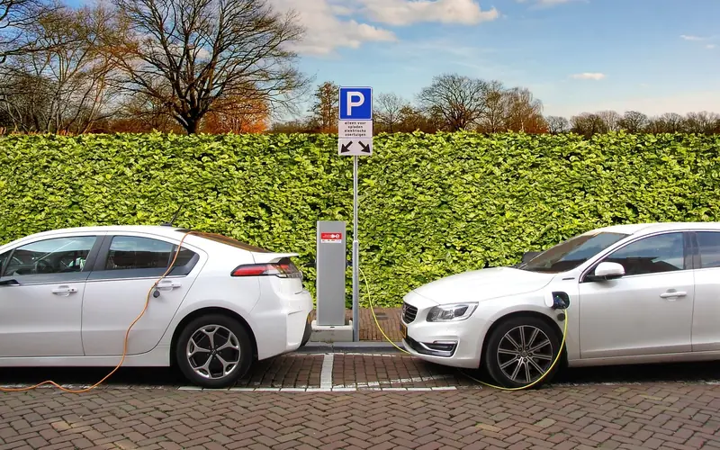 Several electric and hybrid vehicles charging at a curbside charging post Several electric and hybrid vehicles charging at a curbside charging post