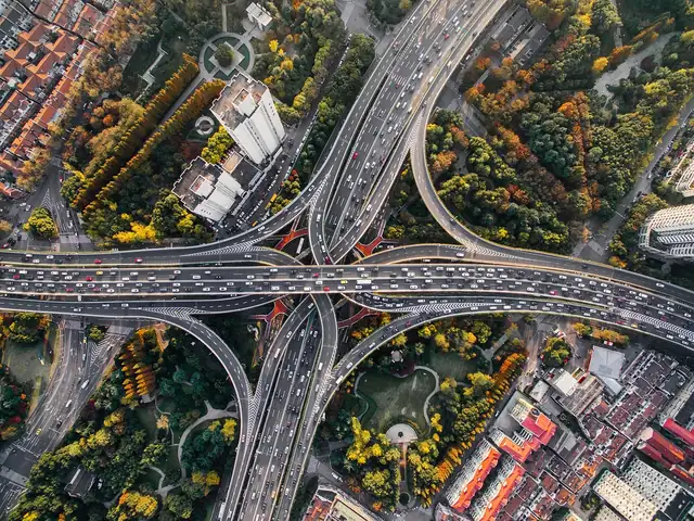 Aerial view of a highway interchange with traffic crossing a city neighborhood