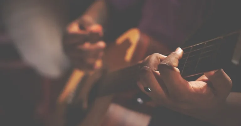 Hands playing an acoustic guitar, the instrument behind Fast Car
