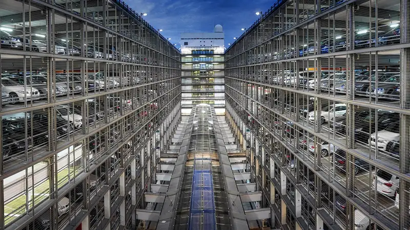 Multi-storey car park lit at dusk with rows of parked cars Multi-storey car park lit at dusk with rows of parked cars