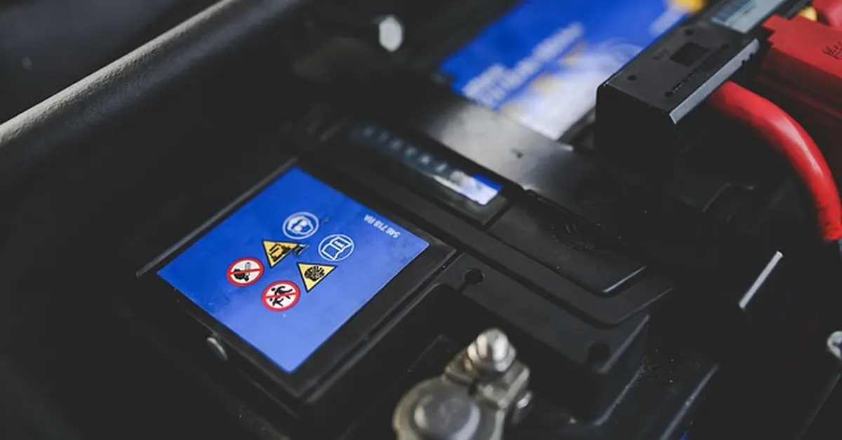 Car battery under the hood of a vehicle