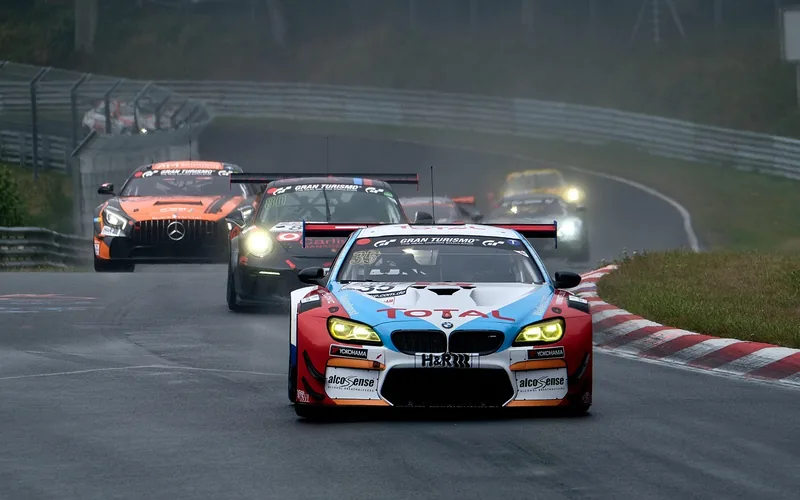 Race cars lined up on a racetrack ahead of a rolling start