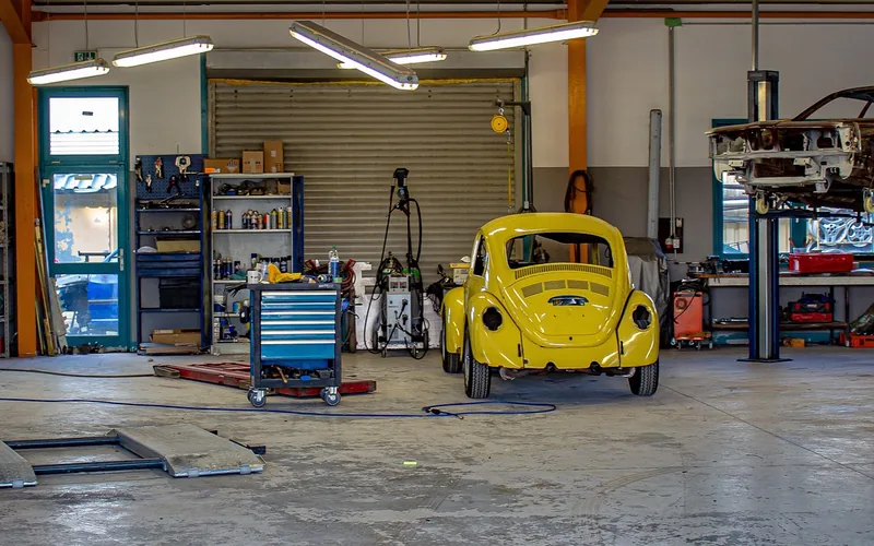 Classic car undergoing restoration work inside a garage workshop