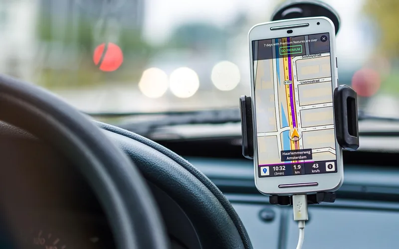 Smartphone mounted on a car dashboard displaying turn-by-turn navigation