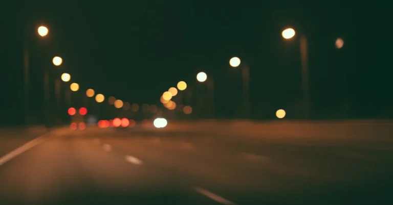 Blurred night road with street lights and car tail lights