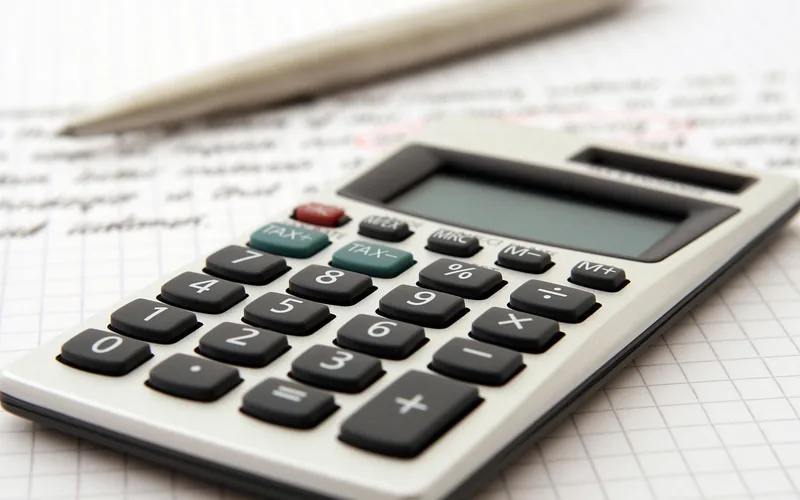 Pocket calculator and pen resting on graph paper for working out loan costs