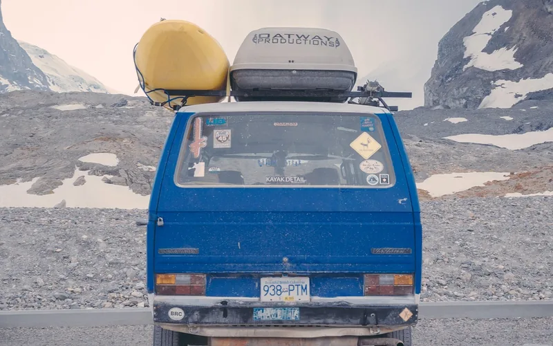 SUV with a loaded rooftop cargo carrier and crossbars driving on a highway during a road trip SUV with a loaded rooftop cargo carrier and crossbars driving on a highway during a road trip