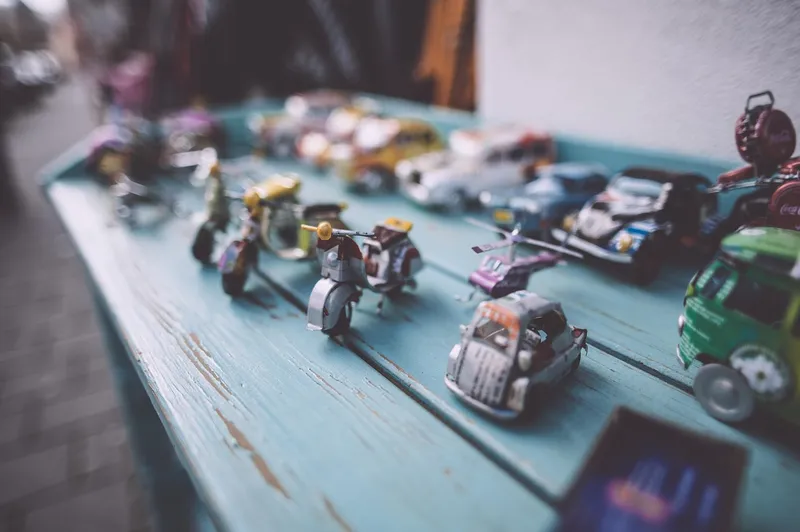 Small collectible model cars lined up on a blue wooden table