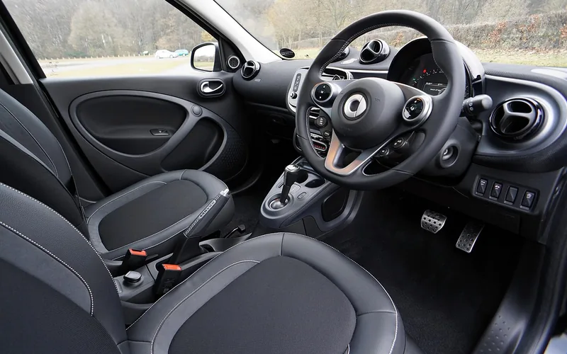 Car interior with a clear floor around the pedals and steering wheel